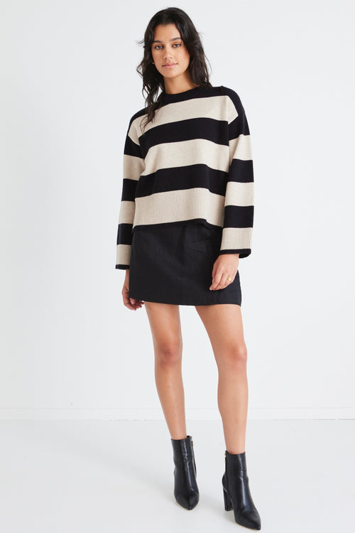 model wears a beige and black stripe knit