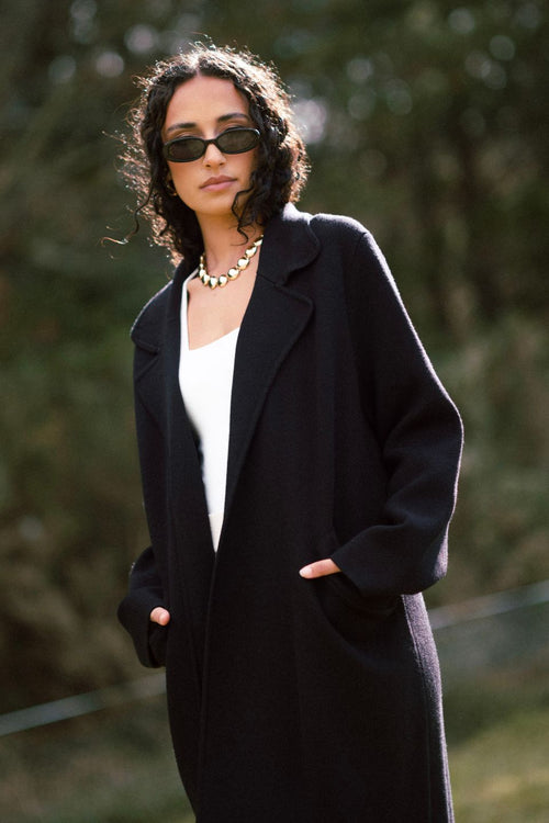 model wears a black coat