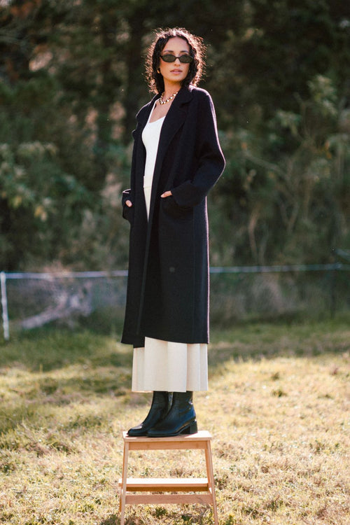 model wears a black coat