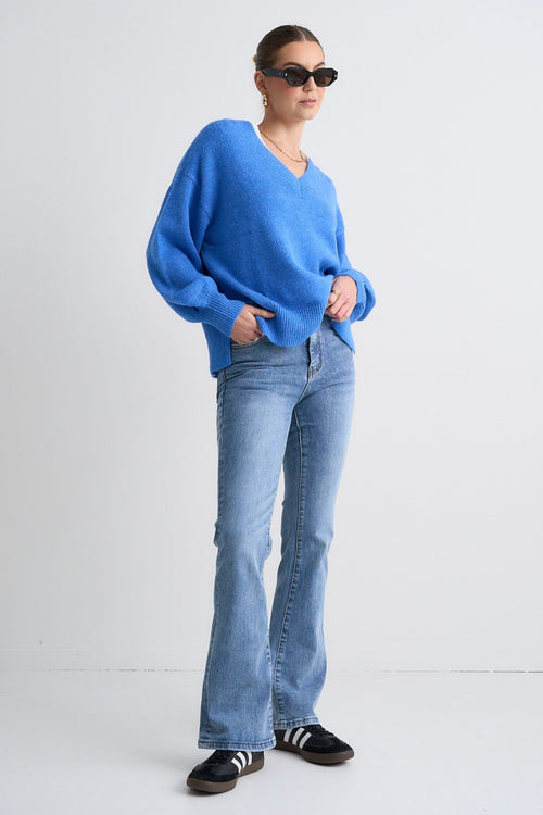 Model wears a blue jumper with jeans