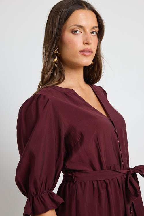 model wears a plum tie tiered dress