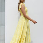 model wearing long yellow maxi dress and black strappy sandals