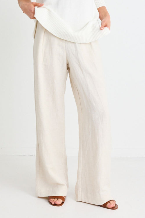 model wears natural linen pants and sandals