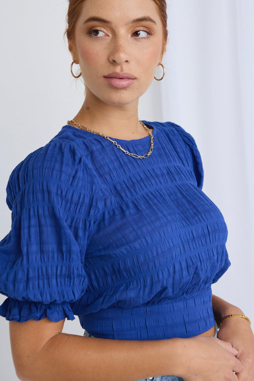 model wears a blue crop top 