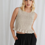 model wears a sleeveless linen top with black pants