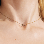 model wearing a gold chain adjustable necklace with a pendant reading "love"