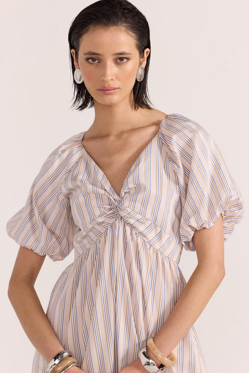 model wears a beige stripe dress