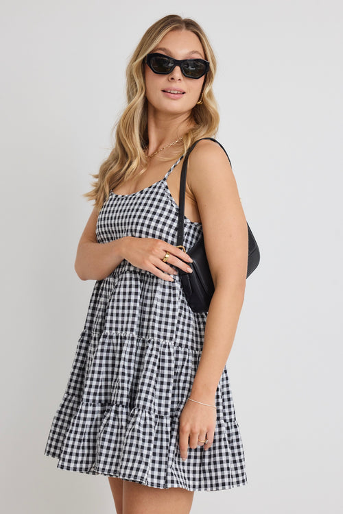 model wears a black and white gingham mini dress