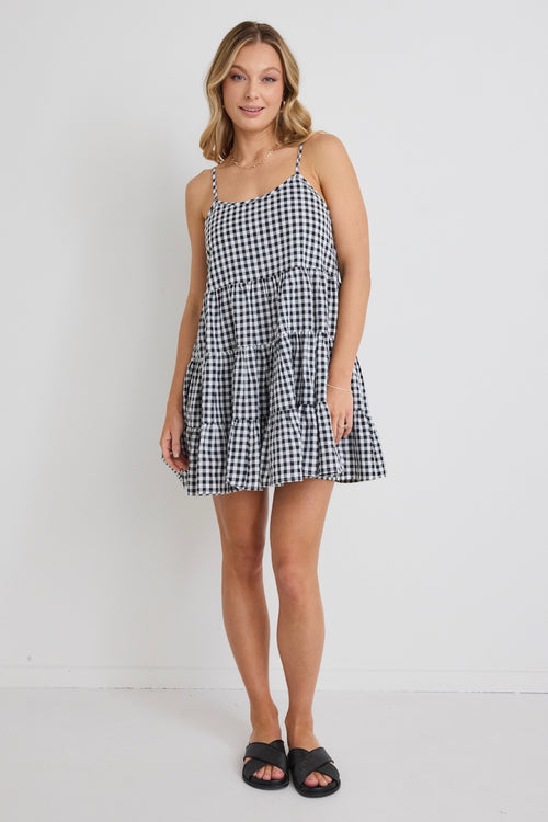 model wears a black and white gingham mini dress