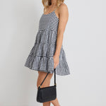 model wears a black and white gingham mini dress