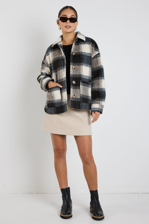 model wears a black and white check jacket