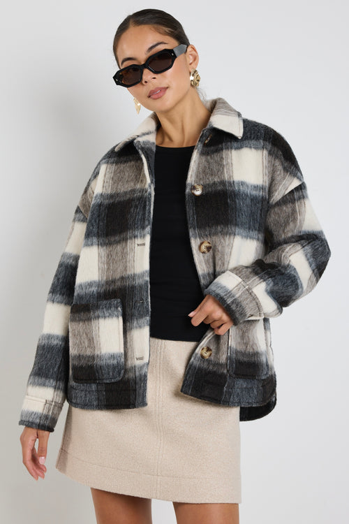 model wears a black and white check jacket