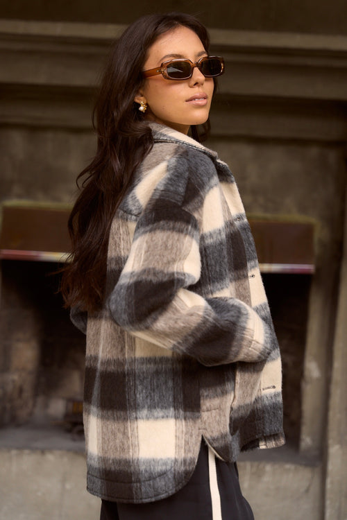 model wears a black and white check jacket