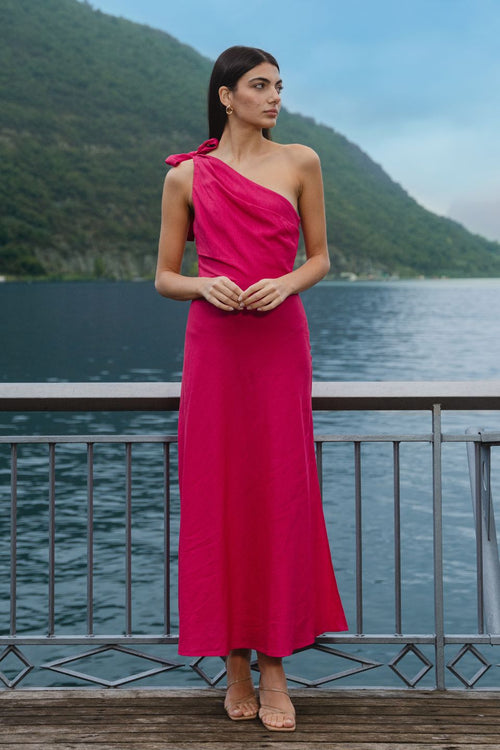 model wears a one shoulder pink midi dress