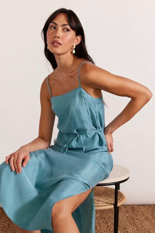 model wears a blue slip dress