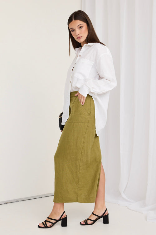 model wears a green skirt and white shirt