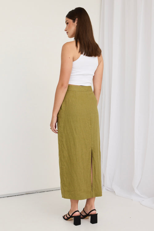 model wears a green skirt and white shirt