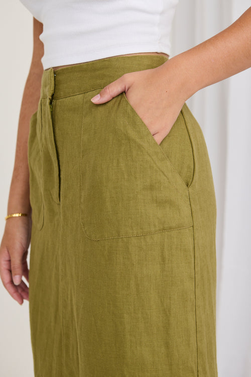 model wears a green skirt and white shirt