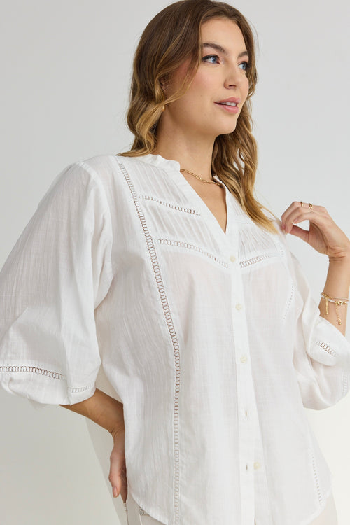 model wears a white button up blouse