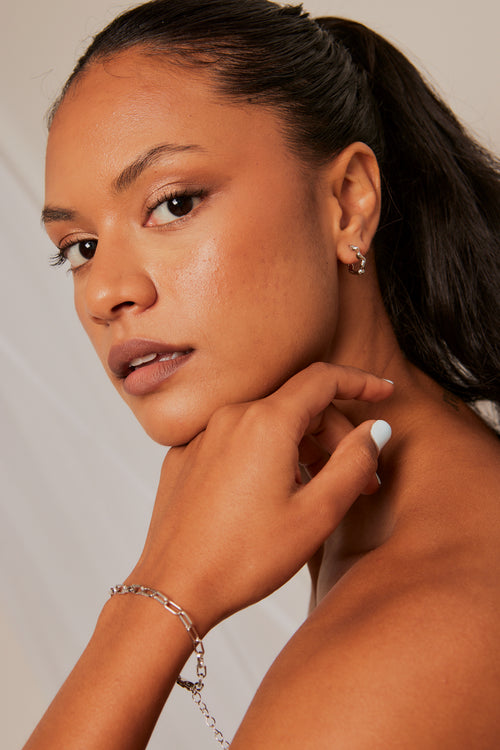 Model wears a silver chain bracelet 