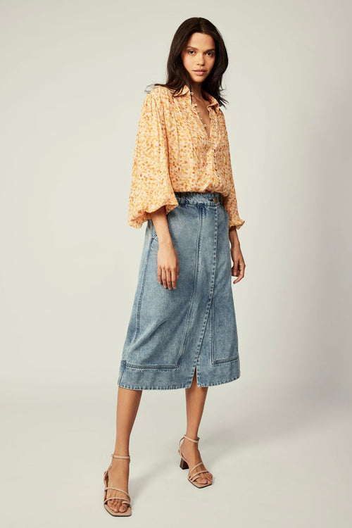 Model wearing orange blouse