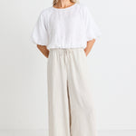 model wears a beige wide leg linen pant