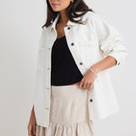 Model wears a ivory white denim jacket with front pockets and button up