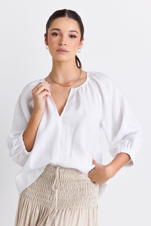 model wears a white linen blouse