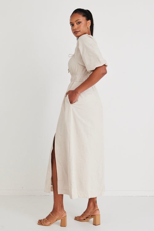 Model wears a linen  midi dress with a slit in the leg. 