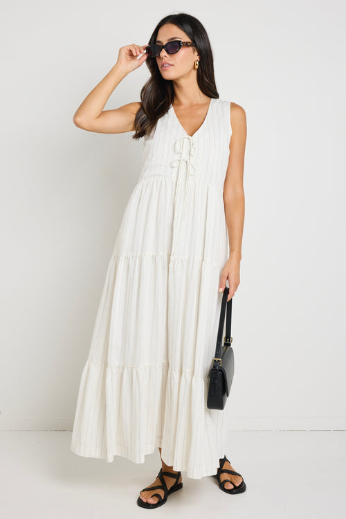 model wears a white stripe maxi dress