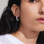 model wearing silver stud hoop earrings