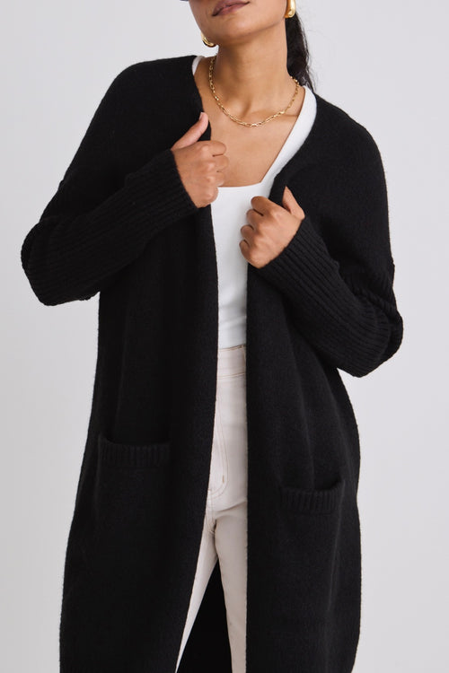 model wears a black cardigan