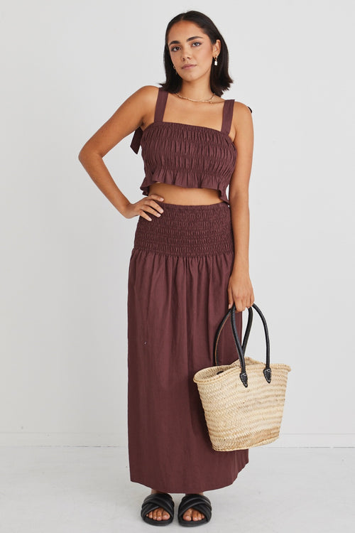 model posing in matching brown crop top and maxi skirt set