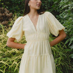 model wears a yellow mini dress