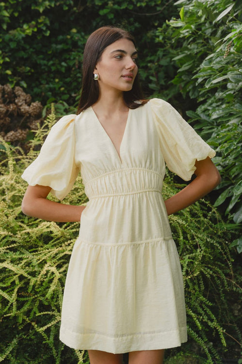 model wears a yellow mini dress