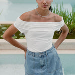 Model wears a white off shoulder top 