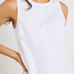 model wears a white linen tank top