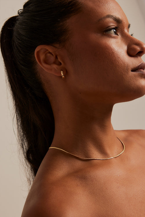 modeling wearing Simple Huggie Gold Earrings