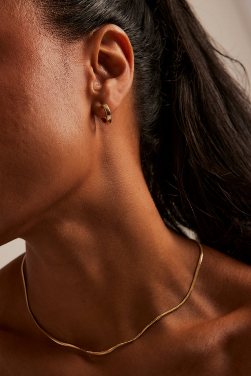 modeling wearing Simple Huggie Gold Earrings