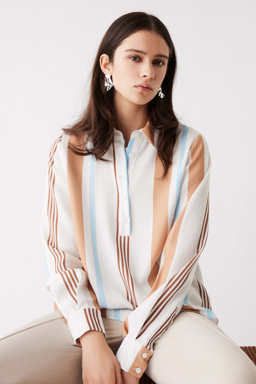 model wears blue, white and brown stripe long sleeve button up shirt