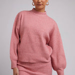 Model wears a Pink Knit with a pink skirt