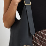 model wears large black leather bag