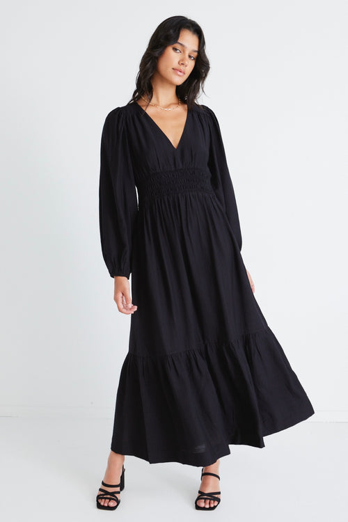 model wears a black maxi dress