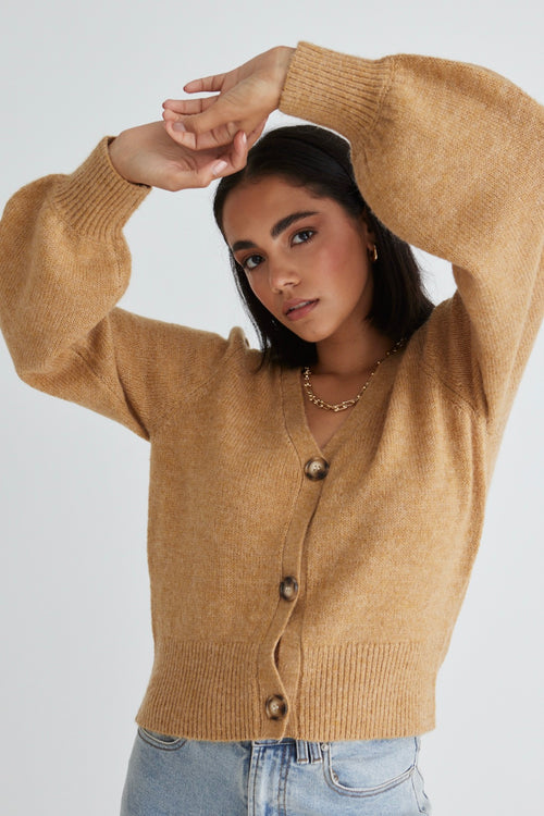 Model wears a gold cardigan