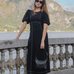 model wears a black midi dress