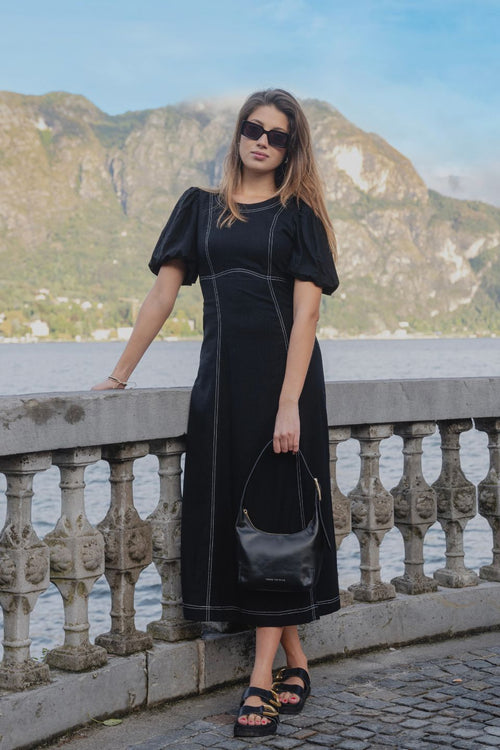 model wears a black midi dress