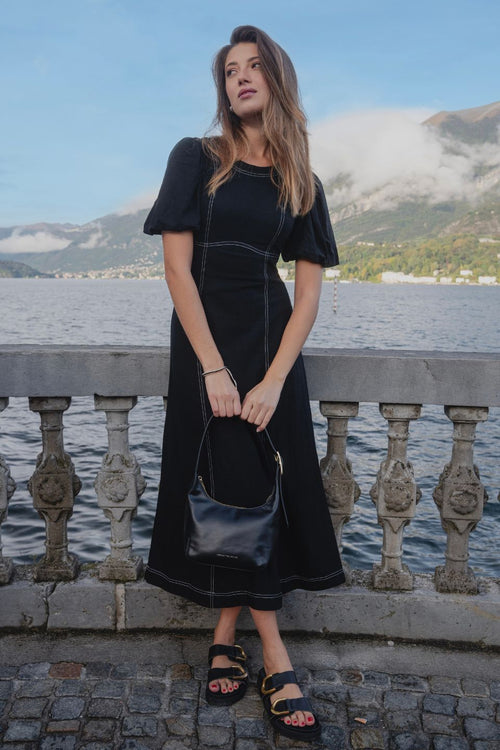 model wears a black midi dress