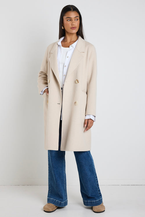 model wears a beige coat