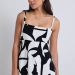 model wears a black and white print top