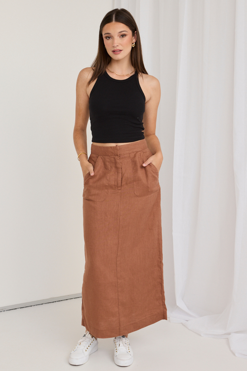 model wears a black tank top and a mocha brown midi skirt with white sneakers